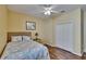 Bedroom with hardwood floors, a patterned bedspread, and a double door closet at 9023 Sienna Moss Ln, Riverview, FL 33578