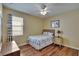 Well-lit bedroom with hardwood floors, a patterned bedspread, and a window with curtains at 9023 Sienna Moss Ln, Riverview, FL 33578