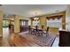 Traditional dining room with hardwood floors, a large table, and natural light from windows at 9023 Sienna Moss Ln, Riverview, FL 33578