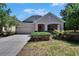 Charming single-story home featuring a two-car garage, well-manicured lawn, and front porch at 9023 Sienna Moss Ln, Riverview, FL 33578