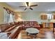 The living room features a comfortable brown sectional, a ceiling fan, and light from the windows at 9023 Sienna Moss Ln, Riverview, FL 33578