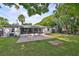 Expansive backyard with lush lawn, brick patio, mature trees, and privacy fence at 913 Chester Dr, Clearwater, FL 33756