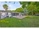 Expansive backyard with lush lawn, brick patio, mature trees, and privacy fence at 913 Chester Dr, Clearwater, FL 33756