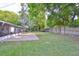 Expansive backyard with lush lawn, brick patio, mature trees, and privacy fence at 913 Chester Dr, Clearwater, FL 33756