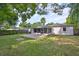 Spacious backyard featuring a patio, screened-in porch, lush lawn, and mature trees creating a peaceful outdoor oasis at 913 Chester Dr, Clearwater, FL 33756