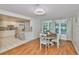 Bright dining area with hardwood floors, a wooden table set, and a view into the open kitchen at 913 Chester Dr, Clearwater, FL 33756