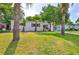 Attractive single-story home with a lush green lawn, palm trees, and tasteful landscaping, adding to its overall charm at 913 Chester Dr, Clearwater, FL 33756
