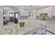Renovated kitchen with granite countertops, new white cabinets, tile flooring, and open layout to other living spaces at 913 Chester Dr, Clearwater, FL 33756