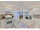 Updated kitchen featuring granite countertops, white cabinetry, stainless steel appliances, and bar seating at 913 Chester Dr, Clearwater, FL 33756