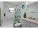 Well-lit bathroom with shower and tub combination features a modern vanity and seashell-themed decor at 9743 36Th N Way # 4, Pinellas Park, FL 33782