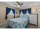 Well-lit bedroom with a bed with blue decorative comforter and matching curtains at 9743 36Th N Way # 4, Pinellas Park, FL 33782