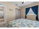 Bedroom with blue curtains, a ceiling fan, and patterned bedding at 9743 36Th N Way # 4, Pinellas Park, FL 33782