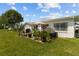 Landscaped patio area with an umbrella-covered table and chairs offers outdoor relaxation next to lush green grass at 9743 36Th N Way # 4, Pinellas Park, FL 33782