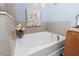 Bright bathroom featuring a tiled wall surrounding a soaking tub with chrome hardware at 10626 Laguna Plains Dr, Riverview, FL 33578