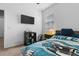 Bright bedroom featuring a twin bed with Eagles bedding, storage solutions and a mounted television at 10626 Laguna Plains Dr, Riverview, FL 33578