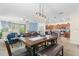 Open-concept dining area with stylish lighting, an expansive table and seating, and a view into the kitchen and living room at 10626 Laguna Plains Dr, Riverview, FL 33578