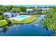 Aerial view of community pool, lush landscaping, and serene pond; perfect for relaxation at 11201 122Nd Ave # 103, Largo, FL 33778
