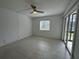 Bright bedroom with tile flooring, a window and sliding glass door to the screened porch at 11201 122Nd Ave # 103, Largo, FL 33778