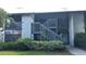Exterior view of the condo featuring stair access, verdant landscaping, and a well-maintained lawn at 11201 122Nd Ave # 103, Largo, FL 33778