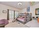 Bright bedroom showcases a gray bunk bed with slide, gray desk, beanbag chair, and natural light at 11205 Lark Landing Ct, Riverview, FL 33569