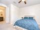 Bedroom with ensuite bathroom, ceiling fan, and blue bedding; neutral walls and carpet at 11205 Lark Landing Ct, Riverview, FL 33569