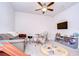 Cozy entertainment room with a gray sofa, drum set, wall-mounted TV, toys, and ceiling fan at 11205 Lark Landing Ct, Riverview, FL 33569