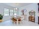 A dining area with a wood table and white chairs illuminated by a chandelier next to a bright window at 11205 Lark Landing Ct, Riverview, FL 33569
