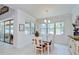 Sunlit dining area features a wood table, white chairs, and views of the outdoor pool and patio at 11205 Lark Landing Ct, Riverview, FL 33569