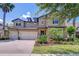 Stunning two-story home featuring a three-car garage, beautiful landscaping and a brick paved driveway at 11205 Lark Landing Ct, Riverview, FL 33569