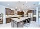 Spacious kitchen features dark wood cabinets, stainless steel appliances, and a large granite island with barstool seating at 11205 Lark Landing Ct, Riverview, FL 33569
