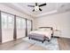 Beautiful bedroom with shutters on the windows, ceiling fan, tray ceiling, and light-colored wood floor at 11205 Lark Landing Ct, Riverview, FL 33569