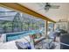 Comfortable outdoor seating area with a view of the screened-in pool and lush landscaping, ideal for relaxation at 11205 Lark Landing Ct, Riverview, FL 33569