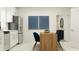 Bright, modern kitchen with white cabinets, stainless steel appliances, and a dining table with stylish blue chairs at 11837 Blue Diamond Trl, Parrish, FL 34219