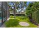Beautiful backyard with green turf, a screened-in lanai, a putting green, and mature trees at 1207 S Druid Ln, Tampa, FL 33629