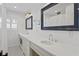 Bathroom with white cabinets, black and white tile flooring and large mirrors and sinks at 1207 S Druid Ln, Tampa, FL 33629
