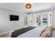 Light-filled bedroom featuring French doors to the pool, a TV, and comfortable decor at 1207 S Druid Ln, Tampa, FL 33629