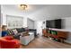 Cozy bonus room featuring a comfortable couch, TV, games, and light-colored wood floors at 1207 S Druid Ln, Tampa, FL 33629