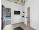Exercise room featuring views of the pool, TV, shelves with equipment, and access to a closet with tiled floor at 1207 S Druid Ln, Tampa, FL 33629