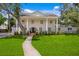 Charming two-story white brick home featuring a columned front porch and landscaped yard at 1207 S Druid Ln, Tampa, FL 33629