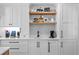 Bright kitchen featuring custom cabinetry with floating shelves, quartz countertops, and modern appliances at 1207 S Druid Ln, Tampa, FL 33629