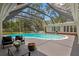 Large screened-in pool with outdoor seating and lush landscaping for a private backyard oasis at 1207 S Druid Ln, Tampa, FL 33629