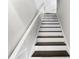 Classic staircase with black treads and white risers offers a timeless design element leading to the upper level at 1207 S Druid Ln, Tampa, FL 33629