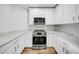 Well-lit kitchen with stainless steel oven, sleek microwave, and modern white cabinetry at 1209 E Cumberland Ave # 2006, Tampa, FL 33602
