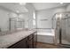 Well-appointed bathroom with a granite vanity, tub, and glass shower at 12256 Creek Preserve Dr, Riverview, FL 33579