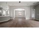 Open living room with wood floors, pendant lighting, and archway to the adjacent kitchen at 12256 Creek Preserve Dr, Riverview, FL 33579