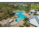 Aerial view showcasing community pool, waterslides, lounge chairs, tennis courts, and landscaping at 12715 Maple Bonsai Dr, Riverview, FL 33579
