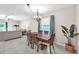 Bright dining area with a wooden table, chandelier, and view into the living room at 12715 Maple Bonsai Dr, Riverview, FL 33579