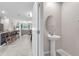 Well-lit powder room with pedestal sink conveniently located near the kitchen and living area at 12715 Maple Bonsai Dr, Riverview, FL 33579