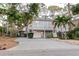 Charming two-story home featuring a spacious driveway and a well-maintained landscaped yard with trees at 138 69Th N Ave, St Petersburg, FL 33702