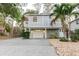 Charming two-story home featuring a spacious driveway and a well-maintained landscaped yard with a palm tree at 138 69Th N Ave, St Petersburg, FL 33702